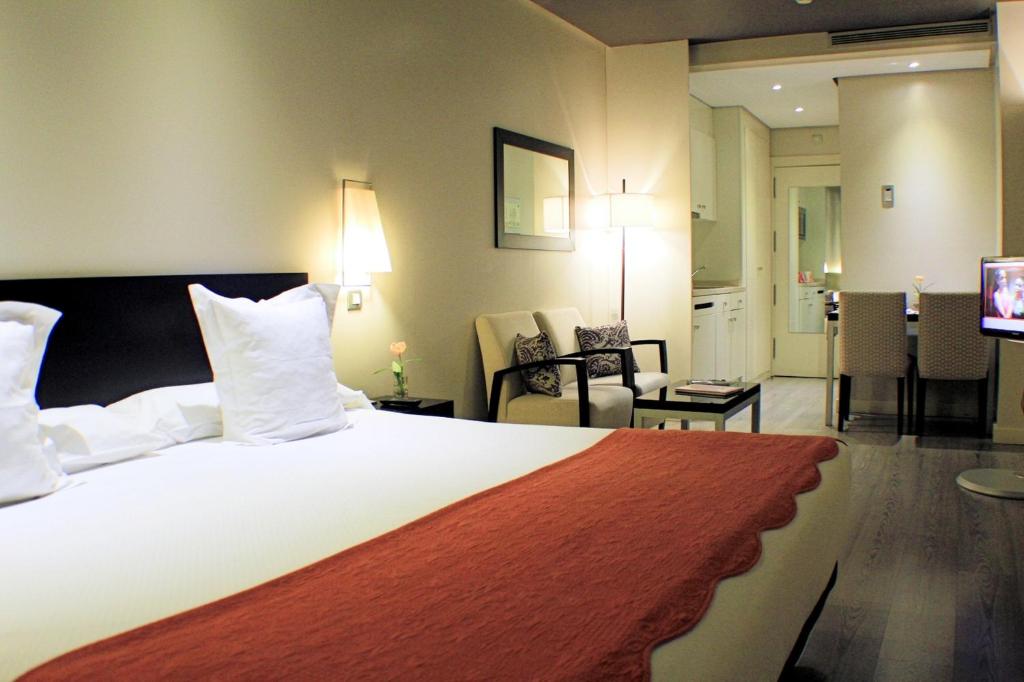 马德里别纳西班牙广场套房酒店的酒店客房设有一张大床和一间客厅。