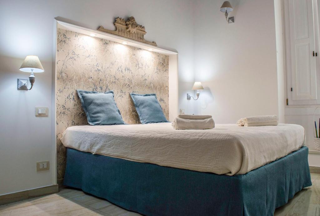 马丁纳弗兰卡Casa Vacanze L'essenziale的一间卧室配有一张带蓝色枕头的大床