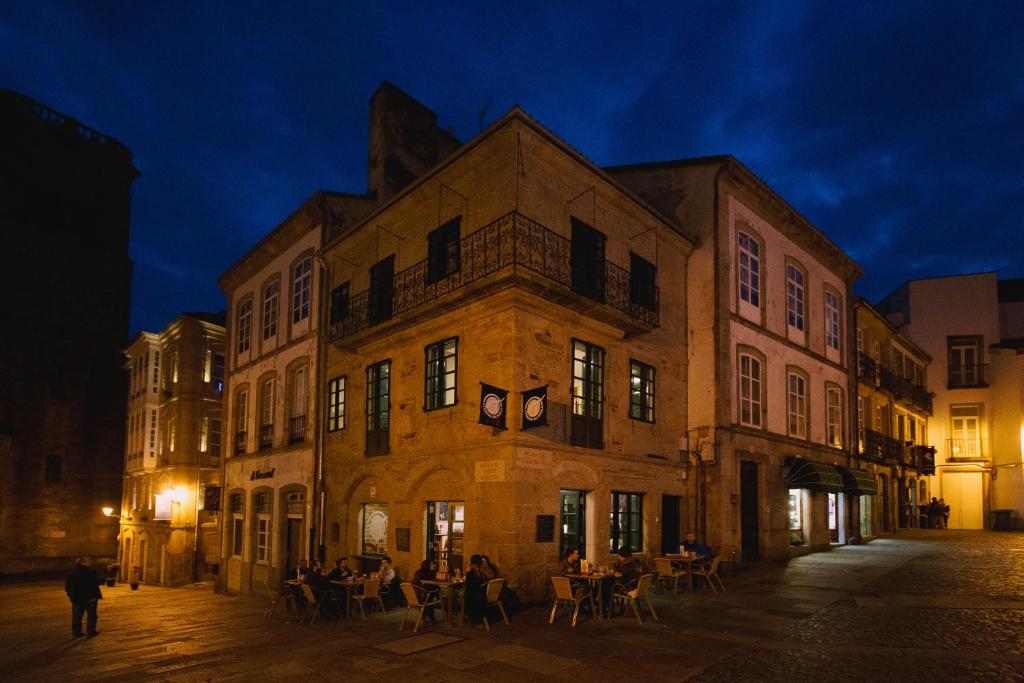 圣地亚哥－德孔波斯特拉豪斯佩德里亚特莱雅旅馆的一座古老的建筑,人们在晚上坐在外面
