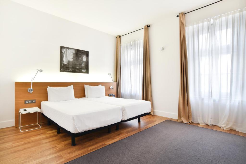布达佩斯布达佩斯泽尼特皇宫酒店的卧室设有白色的床和大窗户