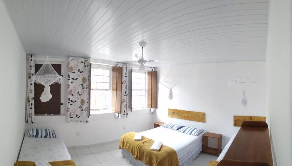 穆库热O Pouso Sobrado的一间白色卧室,配有两张床和窗户