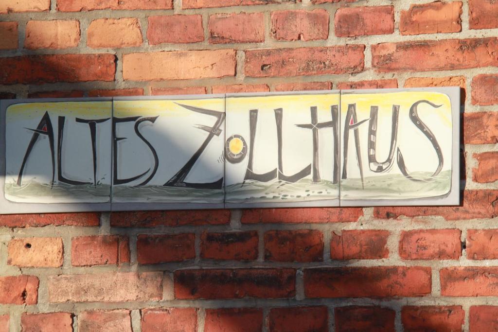 施特拉尔松德Altes Zollhaus Stralsund的砖墙上的标志,上面写着阿提 ⁇ 