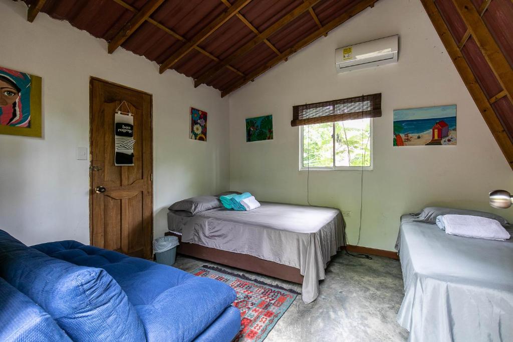 圣维罗尼卡Hostal Campomar的客房设有两张床、一张沙发和一个窗口。