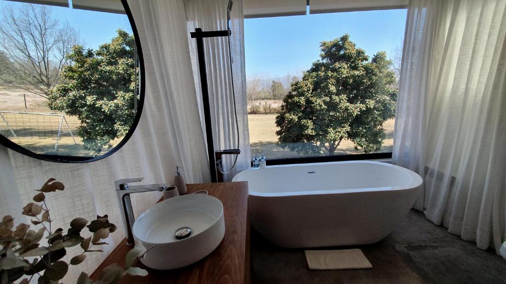查克拉斯德科里亚La Bignonia Posada的带浴缸、卫生间和窗户的浴室