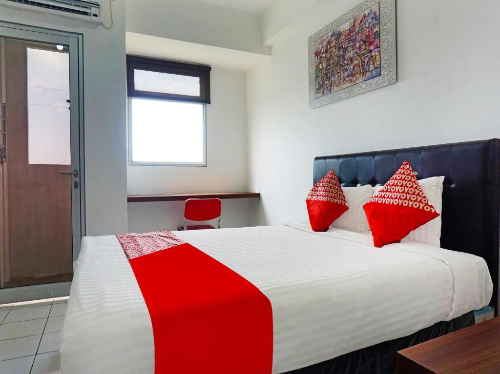 ParungdengdekOYO 91593 San San Rooms Apartment Gunung Putri Square的一间卧室配有一张带红色枕头的大床
