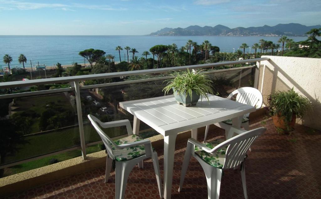 戛纳蒙莫朗西公寓的阳台上配有白色的桌椅,享有海景