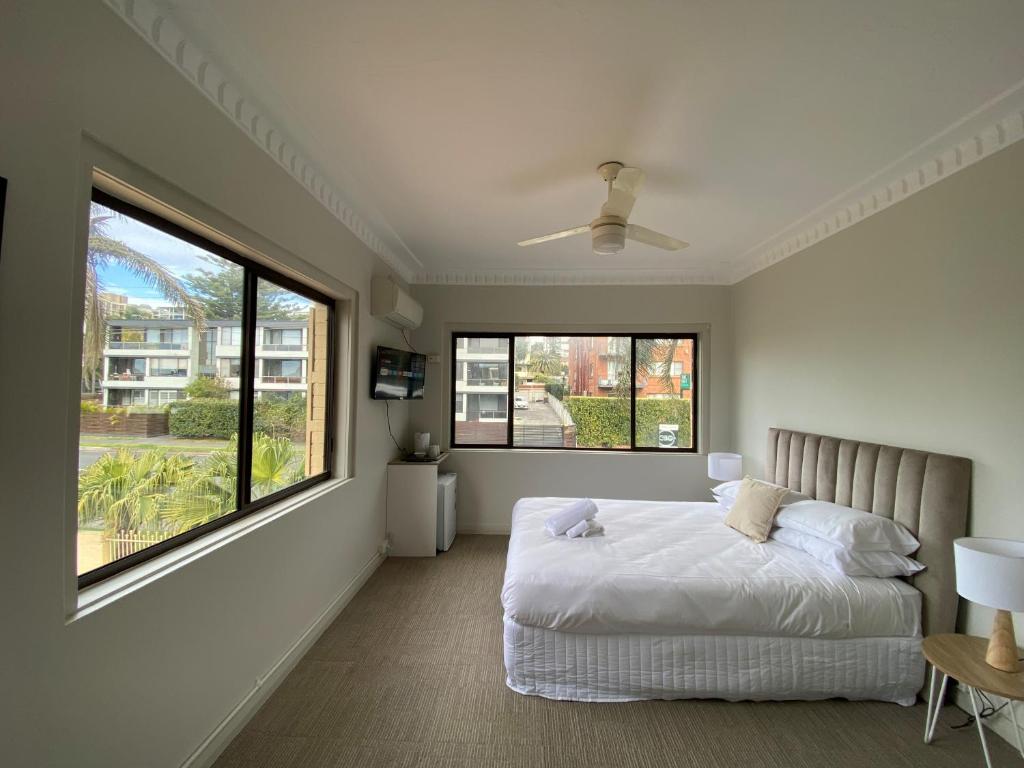 卧龙岗Normandie Wollongong的一间卧室设有一张床和一个大窗户