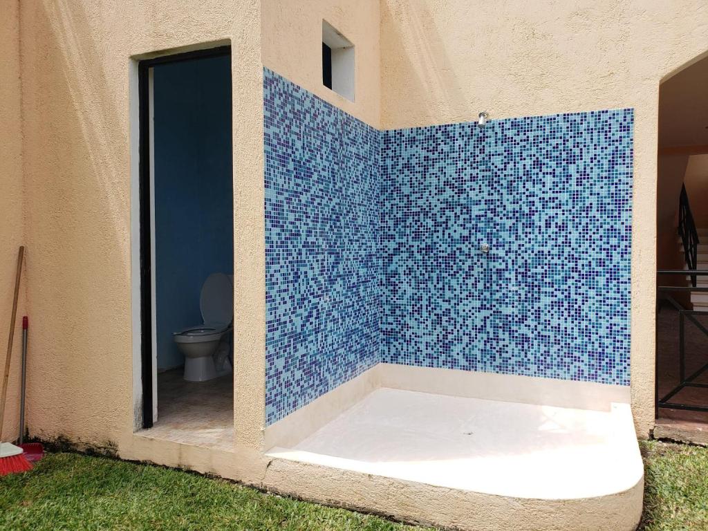 科苏梅尔Coral Island Suites Cozumel的浴室设有蓝色瓷砖墙和卫生间