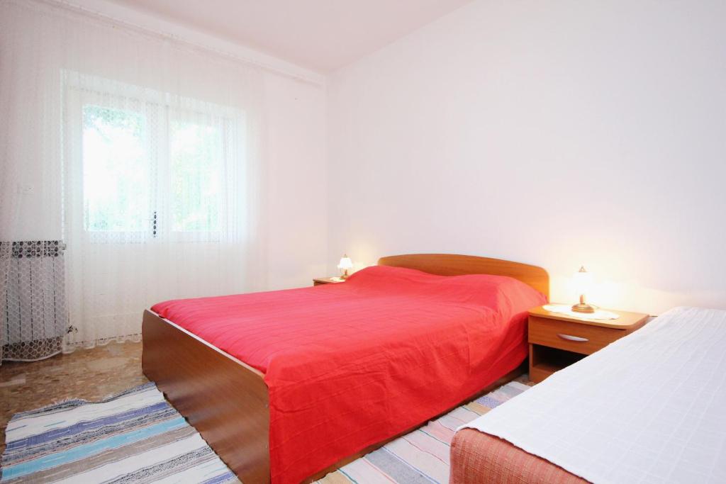 维甘Apartment Viganj 633c的一间卧室设有红色的床和窗户。
