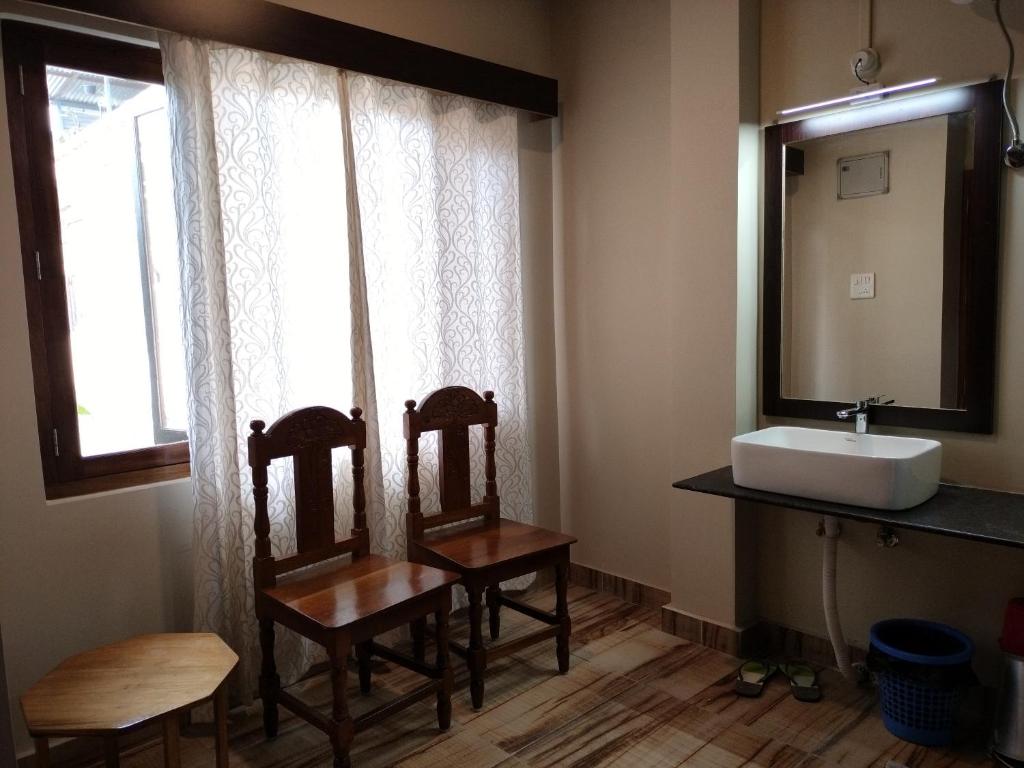 因帕尔John's Home Stay, Imphal, Manipur的浴室设有两把椅子、一个水槽和镜子