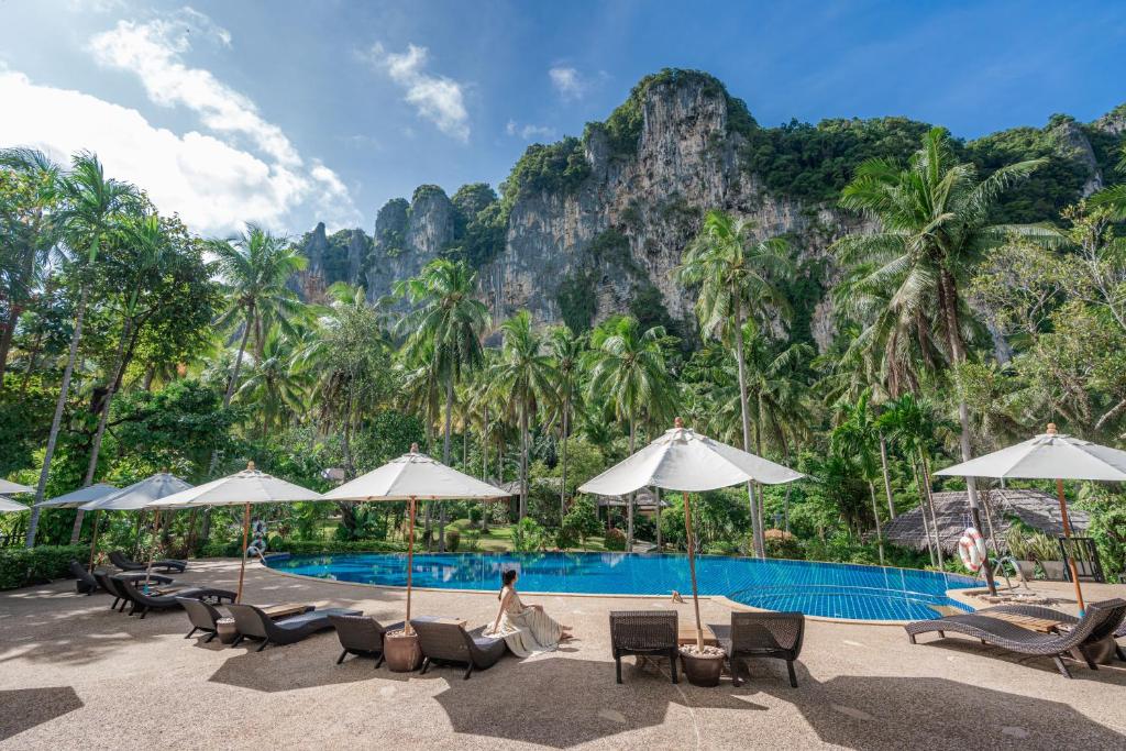 奥南海滩Ban Sainai Resort- SHA Extra Plus Aonang's Green Resort的山前带椅子和遮阳伞的游泳池