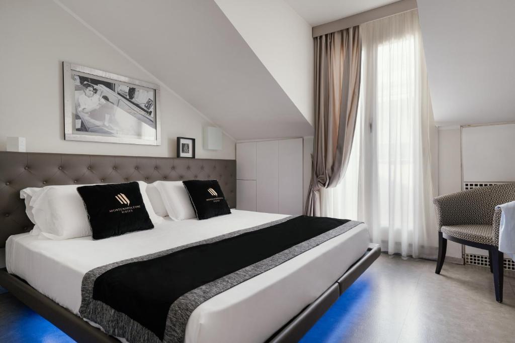 米兰蒙特拿破仑大道套房酒店的卧室配有白色大床和黑白色枕头