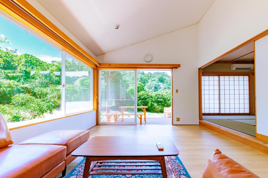 伊东コテージいっぺき湖的客厅配有沙发和桌子