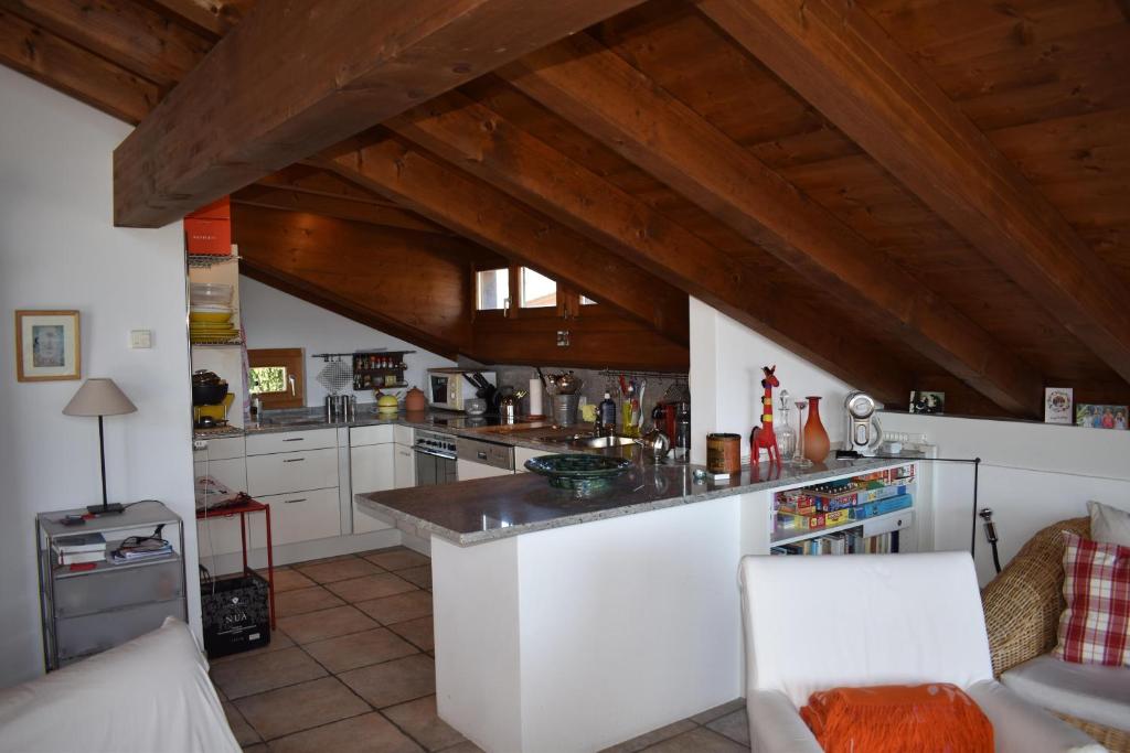 LenzBeal Lia Haus C 474 Bh Whg 8的厨房配有白色橱柜和木制天花板