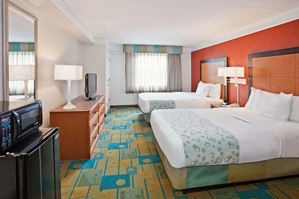 梅里尔维尔Norwood Inn & Suites Merrillville的酒店客房设有两张床和一台平面电视。