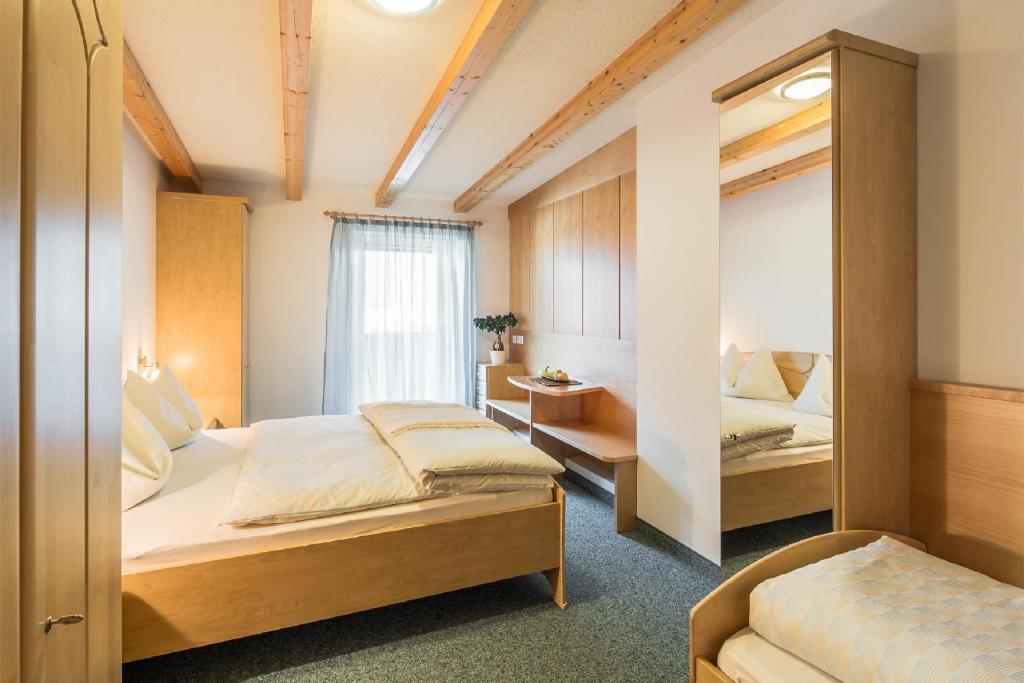 坎波图雷斯Residence Pfeifhofer的一间卧室配有两张床和镜子
