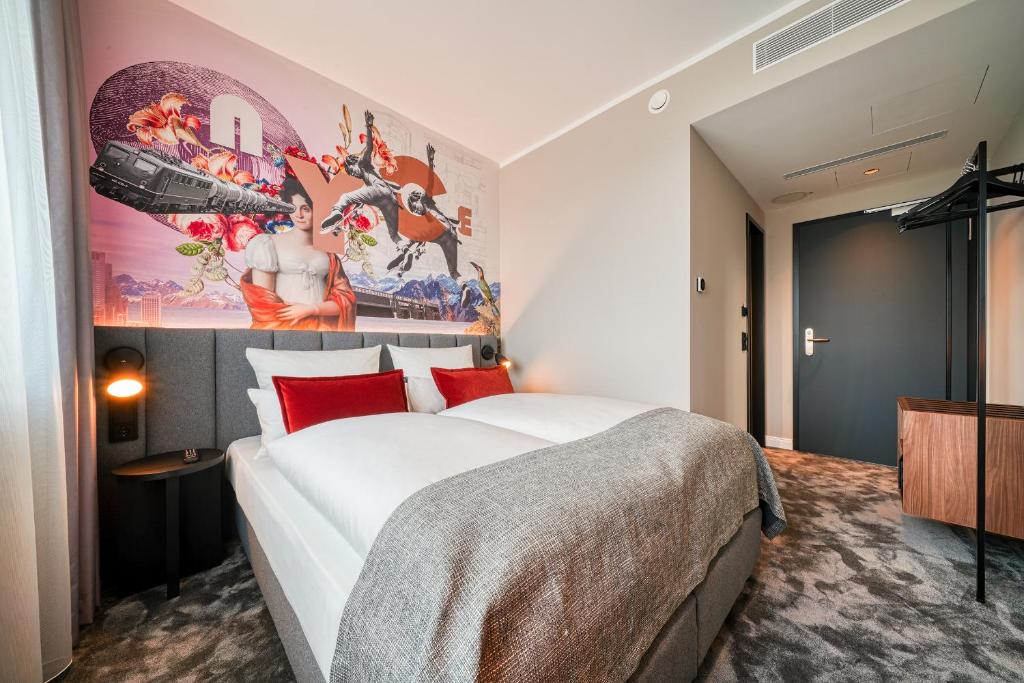 汉诺威NYCE Hotel Hannover的卧室配有一张大床,墙上挂有绘画作品