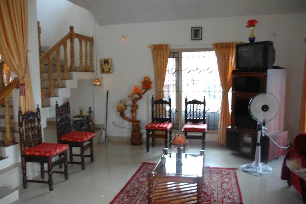 马迪凯里La Paz Coorg homestay at Madikeri town的一间带桌椅的客厅和楼梯