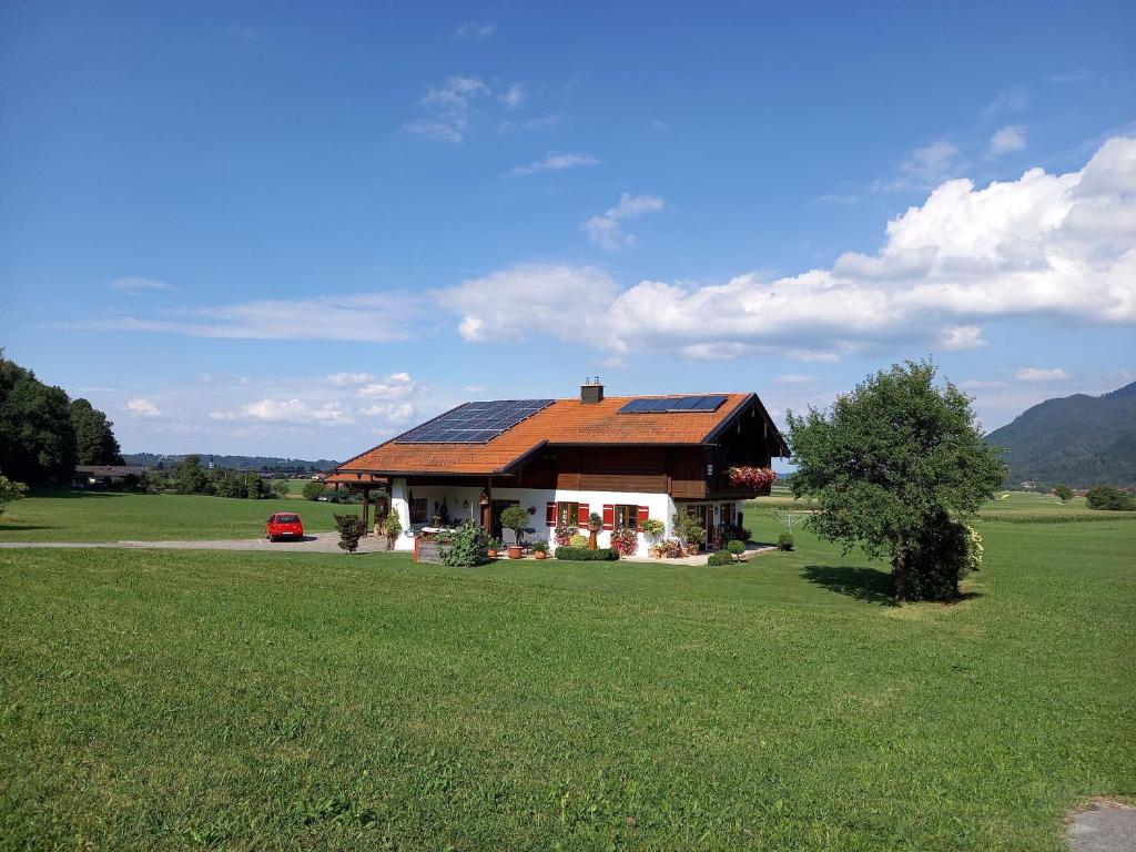 马夸特施泰因Haus Maier的绿色田野上带太阳能屋顶的房子