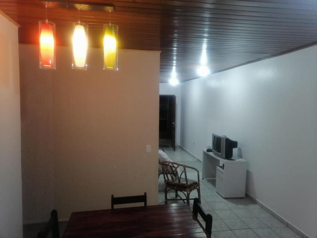伊瓜苏POUSADA APART CATARATAS foz的用餐室配有桌子、电视和灯