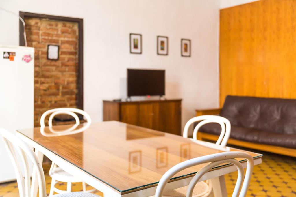 门多萨Alojamiento Aloja N1的一间带桌子和白色椅子的用餐室