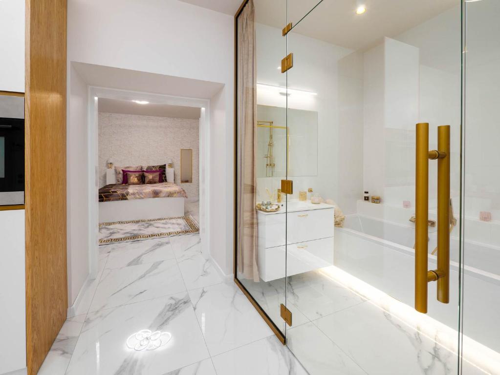 琴斯托霍瓦Apartament Gold Aleja NMP 8 - Free parking的一间带玻璃淋浴间的浴室和一间卧室