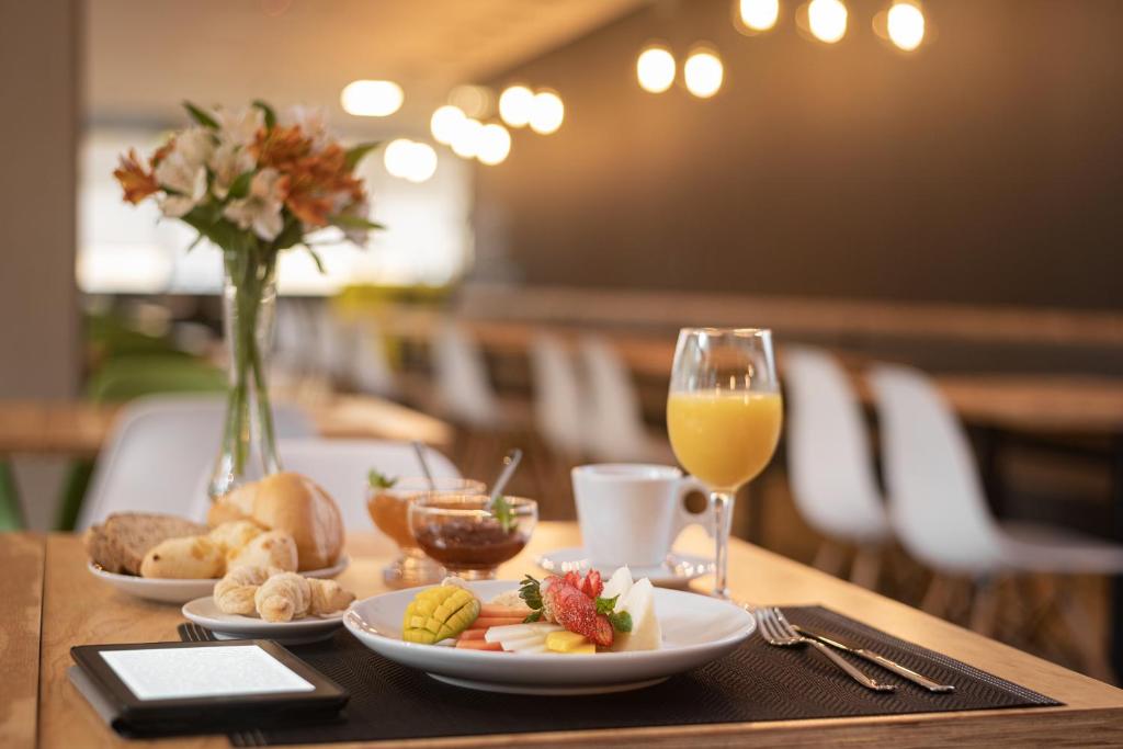 卡诺阿斯Intercity Canoas的餐桌,盘子和一杯橙汁