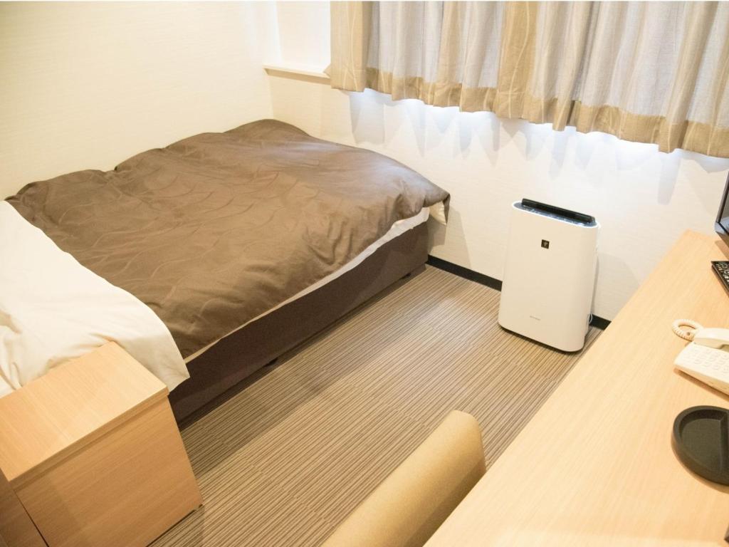 AmakusaHOTEL SUNROAD - Vacation STAY 04184v的一间卧室配有一张床和一张带电脑的书桌