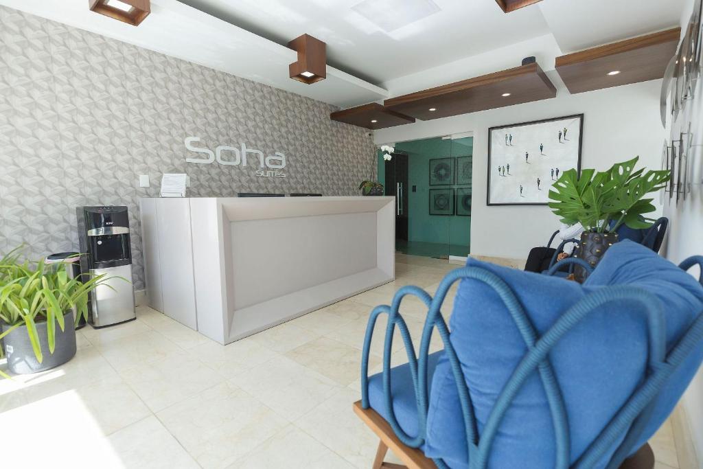 圣地亚哥洛斯卡巴Soha suites I的一个带蓝色椅子的候机室的沙龙