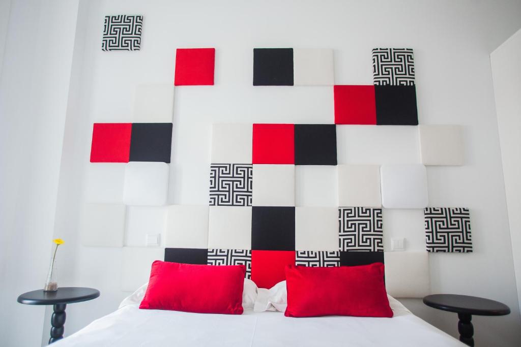 托马尔托玛尔故事旅馆的卧室配有带红色枕头的白色床