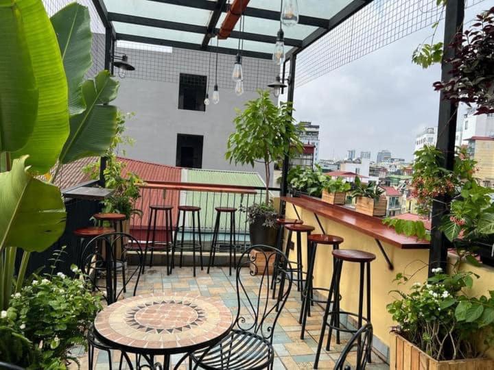 河内Hanoi EcoStay 2 hostel的阳台的天井配有桌椅