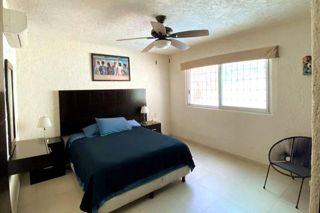 阿卡普尔科Hermoso departamento con alberca的一间卧室配有一张床和吊扇