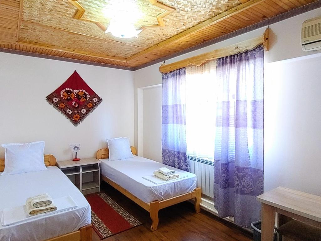 希瓦XIVA AZIM OTA的客房设有两张床和窗户。