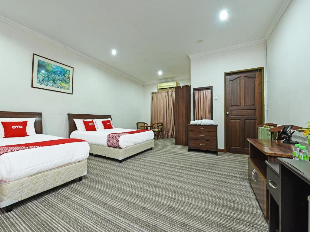 瓜拉丁加奴Super OYO Capital O 90434 Marmoris House的酒店客房配有两张床和一张书桌