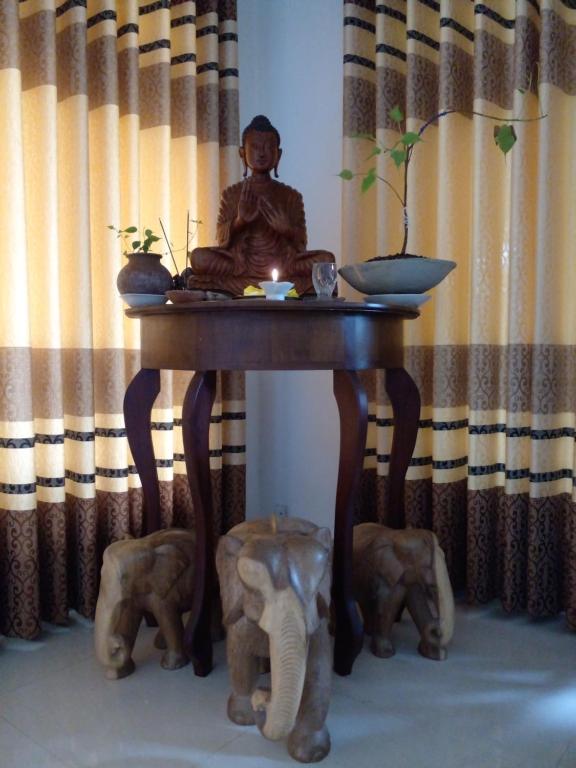 卡卢特勒Muthu Villa Sri Lanka的和大象坐在桌子上的僧侣的雕像