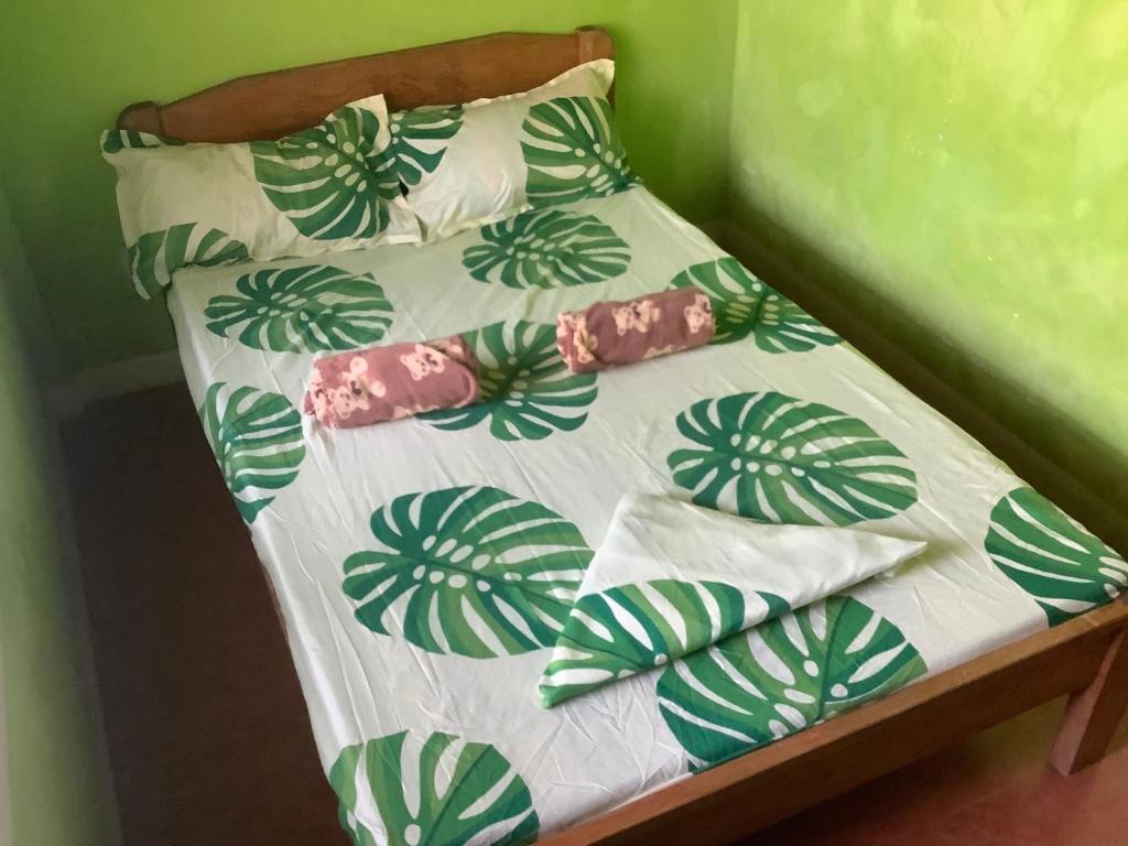 锡帕莱HFA Bldg的一张带绿色和白色床单及枕头的小床