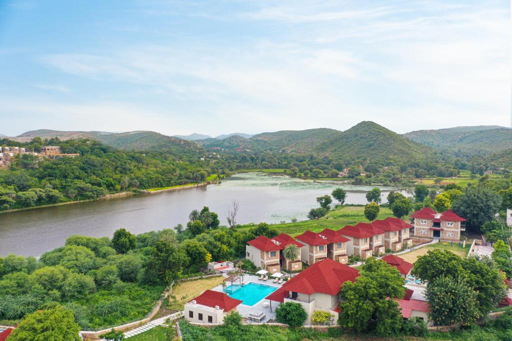 乌代浦Sarasiruham Resort - Private Pool Villa in Udaipur的享有河流和山脉的度假村的空中景致