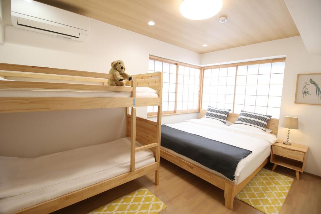东京Uhome Suido Apartment SD的一间卧室设有两张双层床和泰迪熊