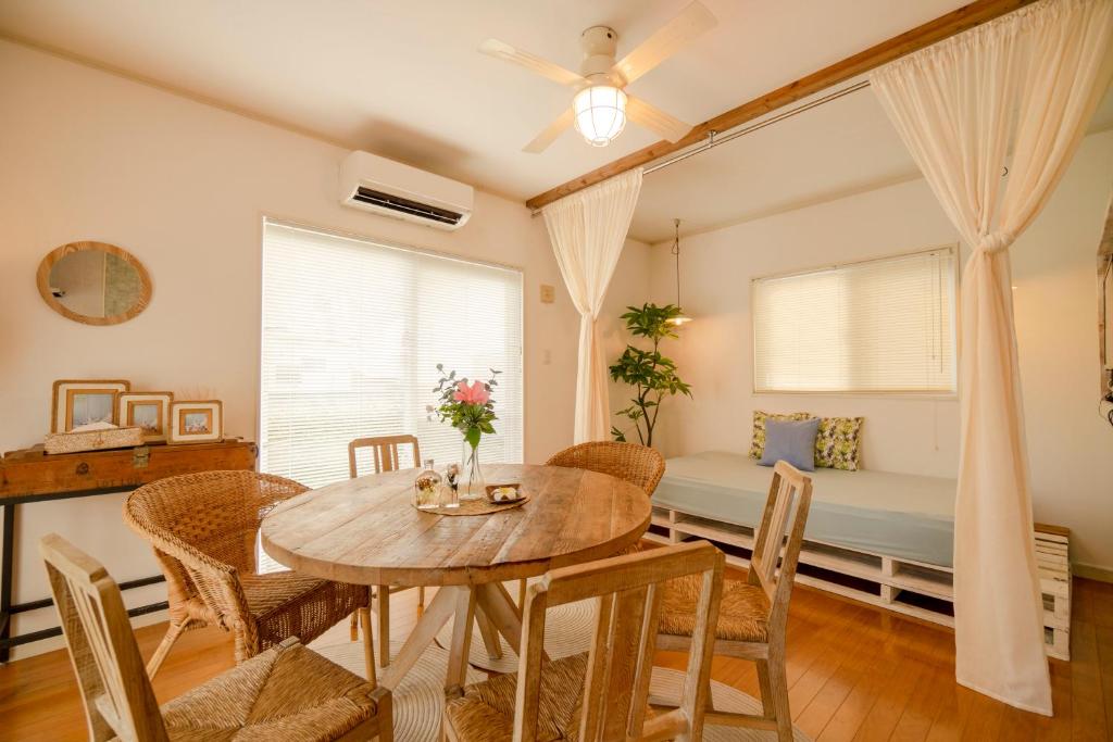 读谷村無料ビーチまで3分!BBQとホームシアターが楽しめるファミリー向け宿 Fujiyama Terrace的一间带桌椅和一张床的用餐室