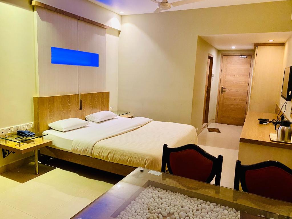 罗纳瓦拉Hotel Rama Krishna的一间卧室配有一张床和一张桌子及椅子
