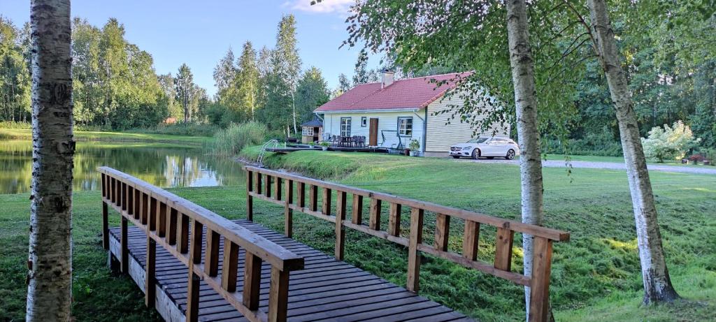 NasvaNinnujärve Private Holiday Home的通往房屋和湖泊的木桥