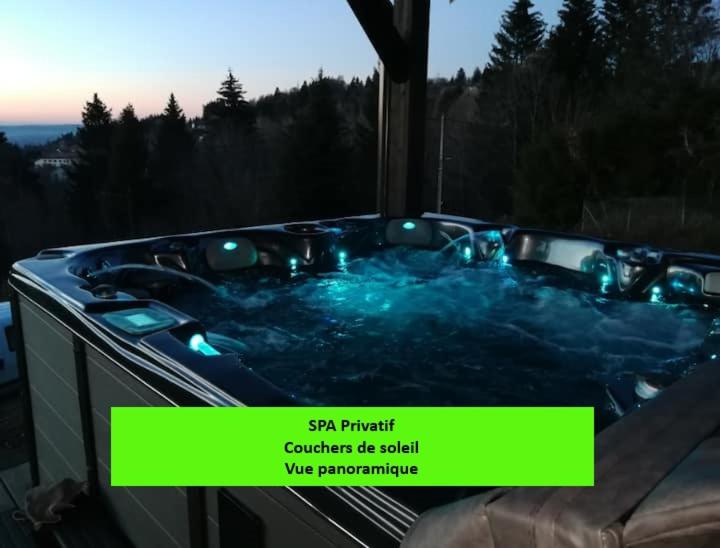 BelfahyChalet neuf avec jacuzzi privé, vue imprenable sur Massif des Vosges的一个带灯光和标志的按摩浴缸,用来阅读