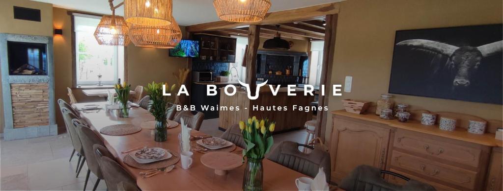 韦姆B&B La Bouverie HF的一间带桌椅和电视的用餐室