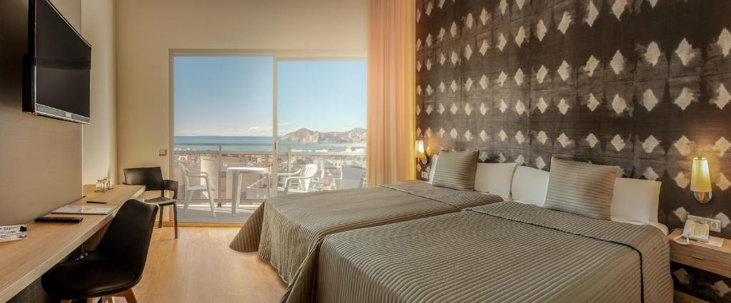 贝尼多姆RH Princesa Hotel & Spa 4* Sup的一间卧室配有一张床、一张书桌和一个窗户。