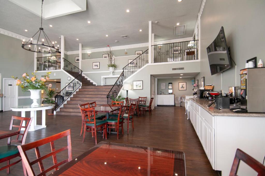 橙县最佳价格套房汽车旅馆的一间带桌椅和楼梯的餐厅