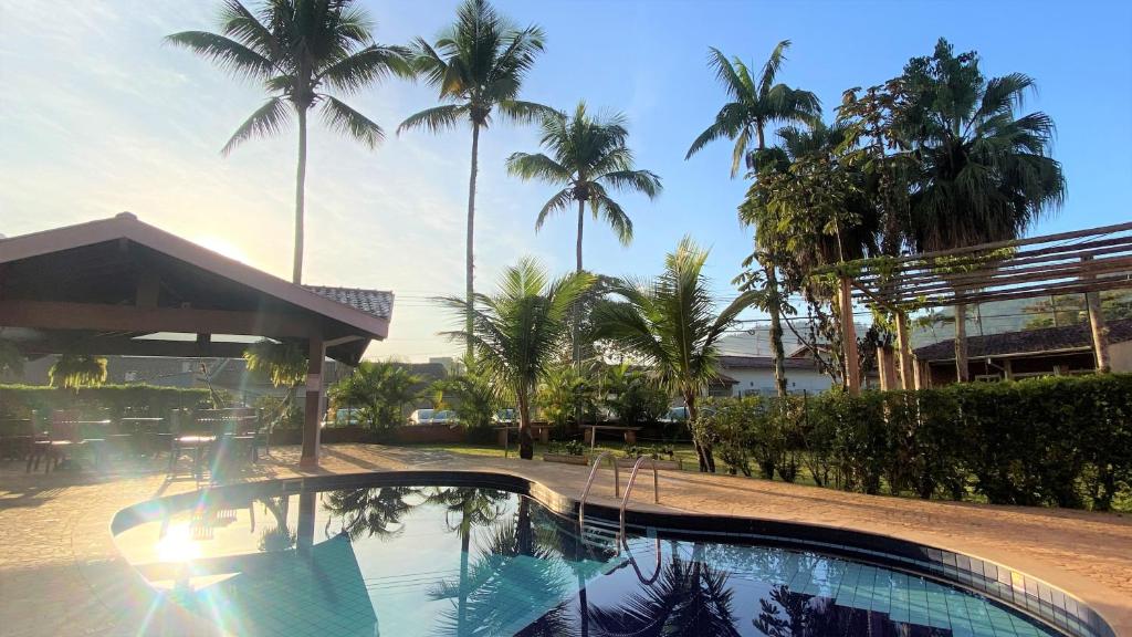 乌巴图巴De Bem K Vida的一座棕榈树环绕的游泳池