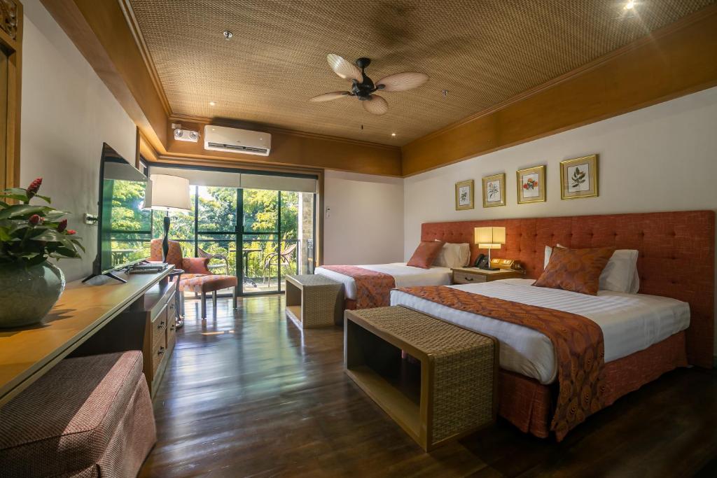 Istorya Forest Garden Resort的酒店客房设有两张床和电视。
