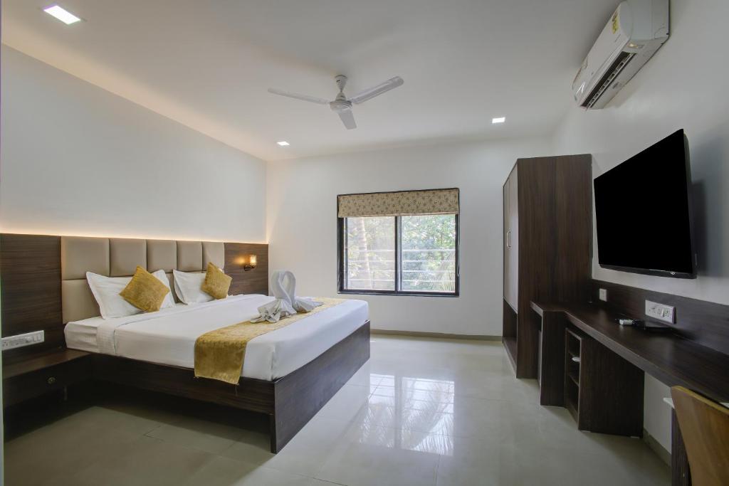 浦那StayBird - AERITH STUDIOS, Exclusive Residences, Kharadi的一间卧室配有一张大床和一台平面电视