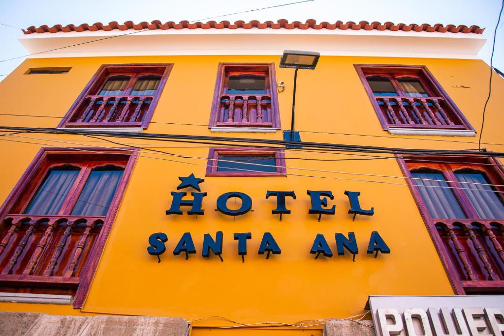阿亚库乔Hotel Santa Ana的黄色建筑,标有酒店标志