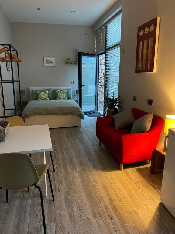 布瑞Hugo Mews Bright Studio Apartment的客厅配有红色的沙发和床。